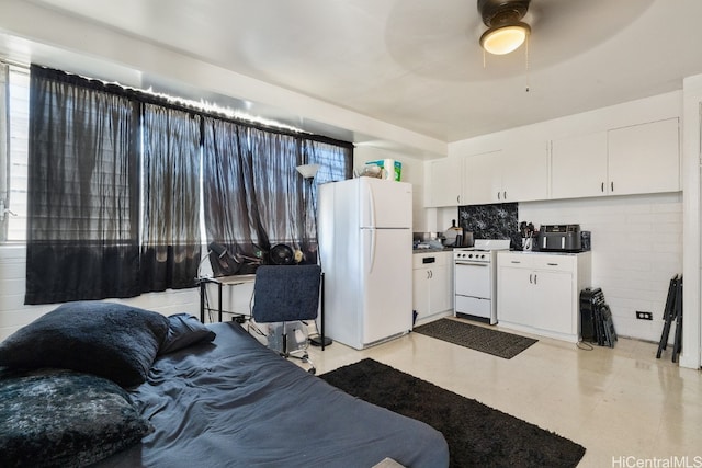 kitchen featuring white appliances, ceiling fan, white cabinetry, and a wealth of natural light