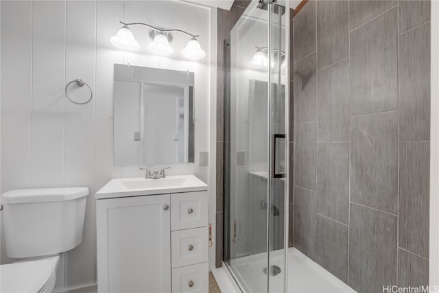 bathroom featuring toilet, an enclosed shower, and vanity