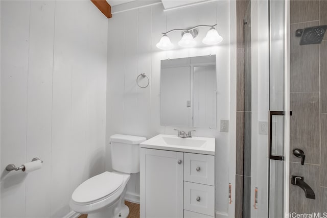 bathroom featuring vanity, toilet, and wooden walls