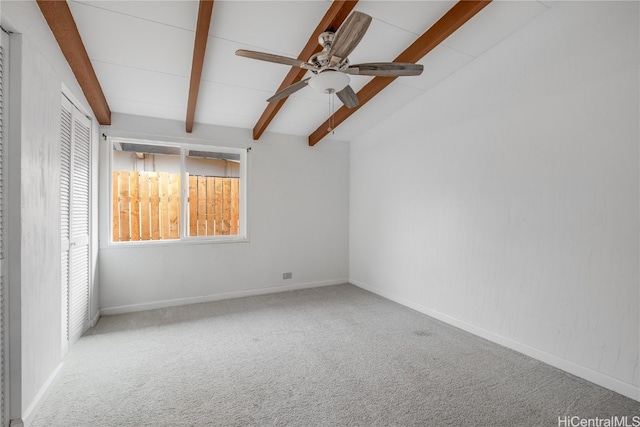 empty room with vaulted ceiling with beams, ceiling fan, and light colored carpet