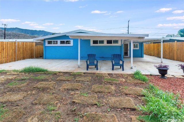 rear view of property with a mountain view and a patio