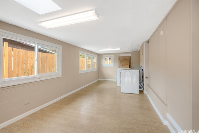 laundry area featuring light hardwood / wood-style floors and a skylight