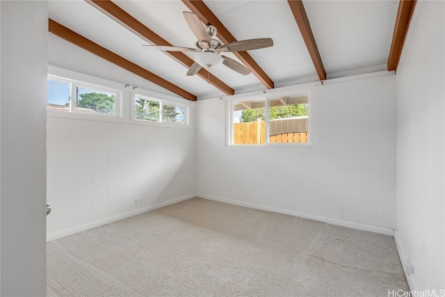 spare room featuring light carpet, vaulted ceiling with beams, ceiling fan, and brick wall