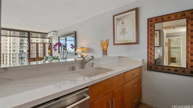 bathroom featuring vanity, a textured ceiling, and an AC wall unit