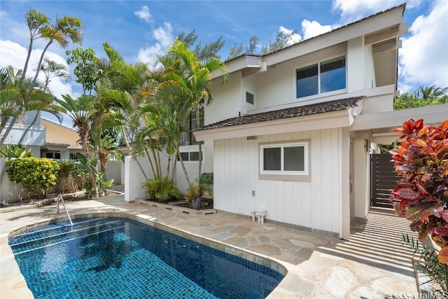 rear view of house with a patio and a fenced in pool