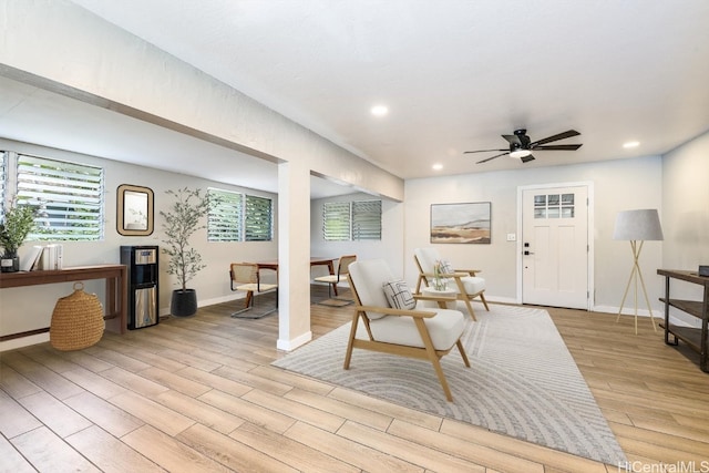 living room featuring light hardwood / wood-style flooring and ceiling fan