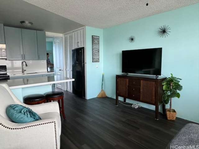 living room with a textured ceiling and dark wood-style flooring