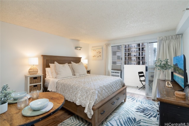 bedroom with a textured ceiling and light hardwood / wood-style flooring