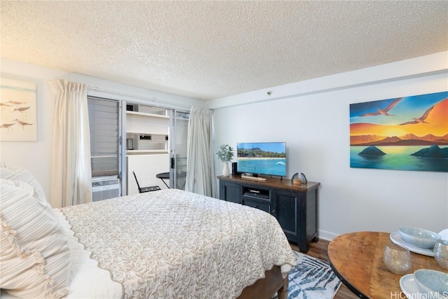 bedroom with cooling unit, dark wood-type flooring, and a textured ceiling