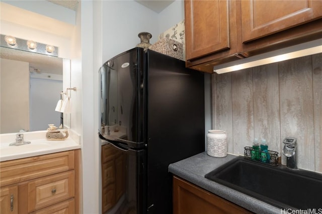 kitchen featuring black fridge and sink