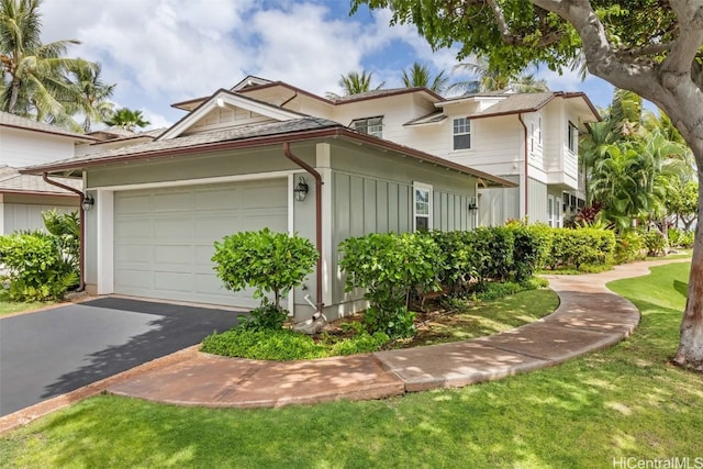 view of home's exterior with a garage and a lawn