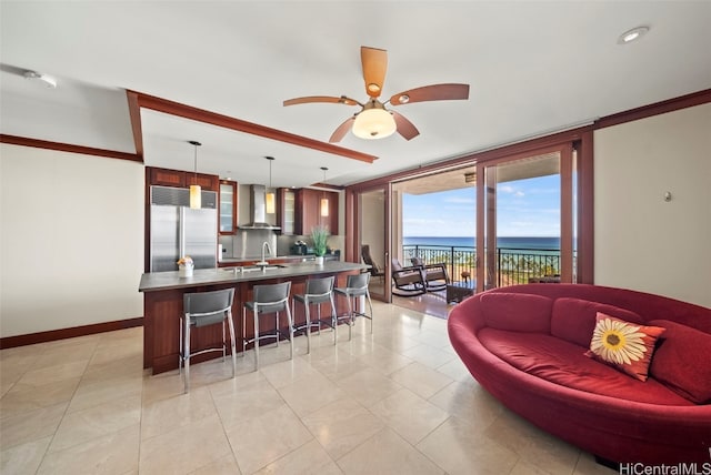 tiled living room featuring a water view, ceiling fan, and sink