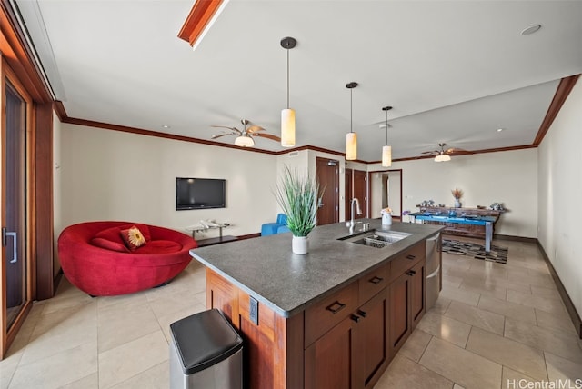 kitchen featuring pendant lighting, a center island with sink, ornamental molding, and sink