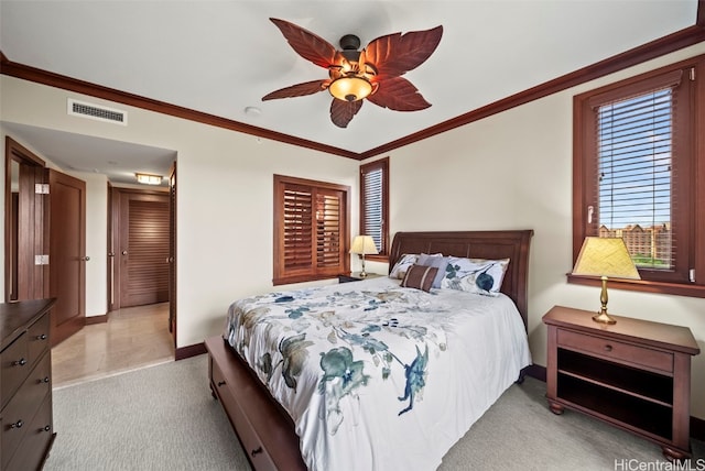 carpeted bedroom featuring ceiling fan and crown molding