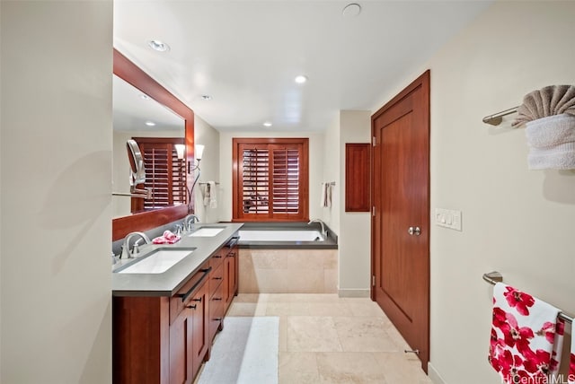 bathroom featuring tile patterned flooring, vanity, and tiled bath