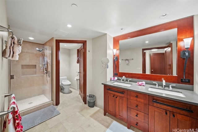 bathroom featuring tile patterned floors, vanity, a shower with shower door, and toilet