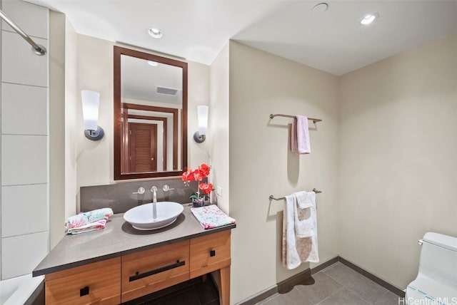 bathroom with tile patterned flooring, vanity, and toilet