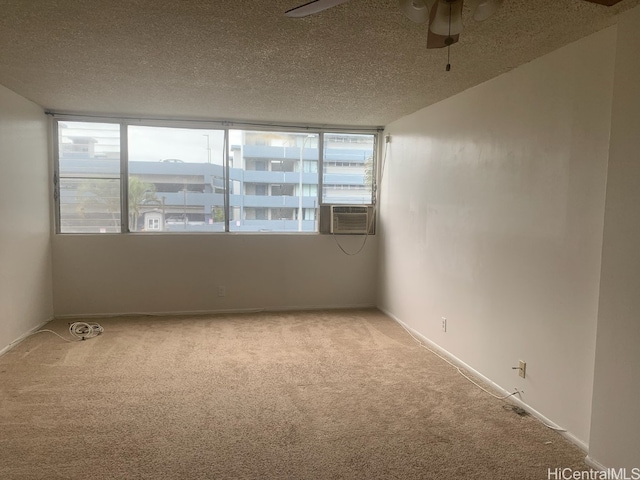 spare room featuring light carpet, a textured ceiling, cooling unit, and ceiling fan