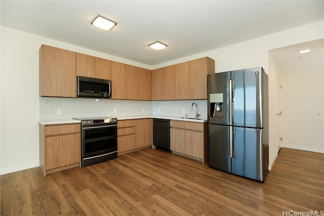 kitchen with dark wood-type flooring, appliances with stainless steel finishes, sink, and decorative backsplash