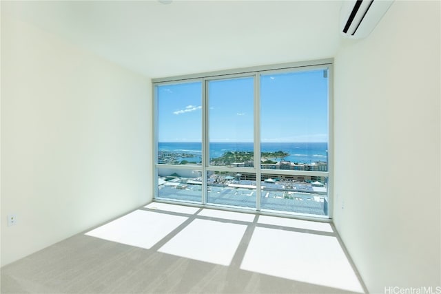 carpeted spare room with an AC wall unit, a water view, and floor to ceiling windows