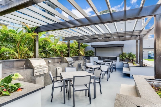 view of patio with exterior kitchen, grilling area, and a pergola