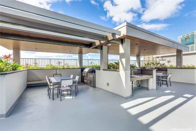 view of patio with area for grilling, a bar, and a grill