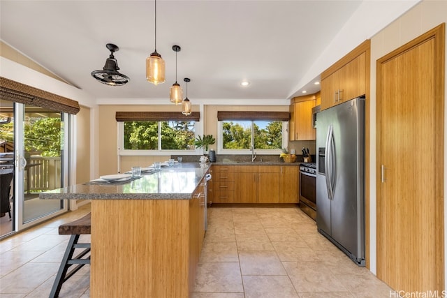 kitchen featuring a breakfast bar, light tile patterned floors, appliances with stainless steel finishes, and sink