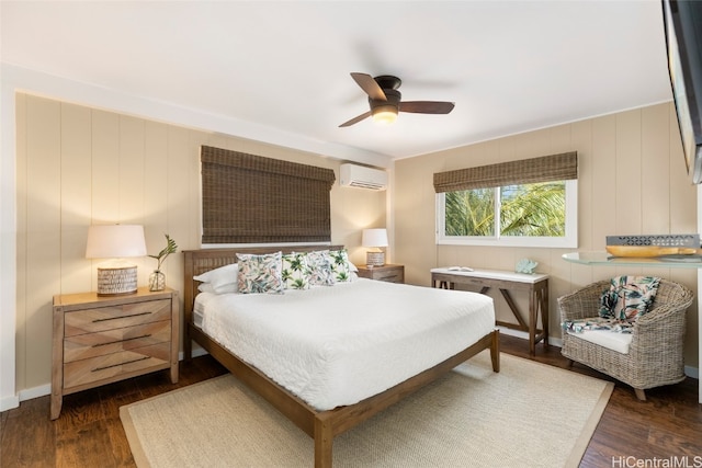 bedroom featuring dark wood-type flooring, a wall unit AC, wooden walls, and ceiling fan