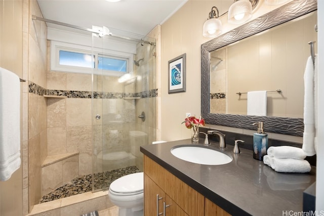 bathroom featuring vanity, toilet, and a shower with door