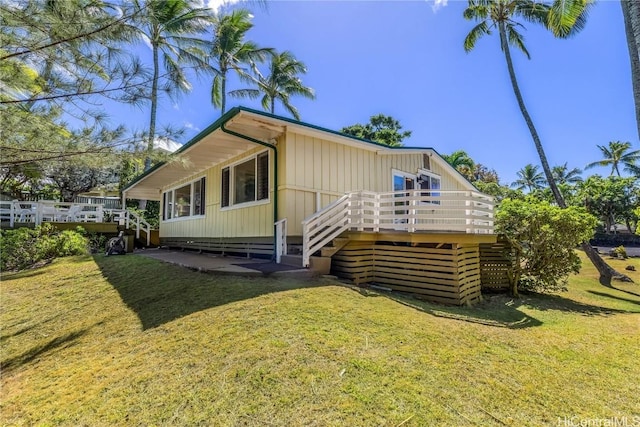 exterior space featuring a deck, a lawn, and stairs