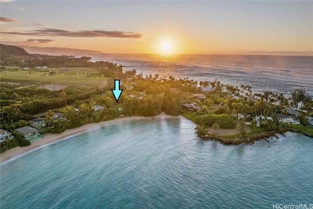 aerial view at dusk featuring a beach view and a water view