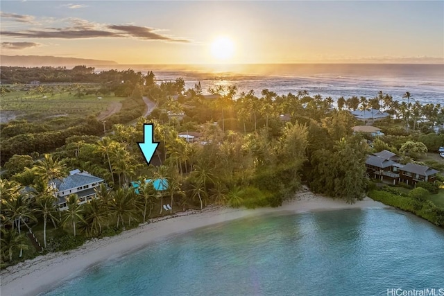 aerial view at dusk with a water view and a beach view