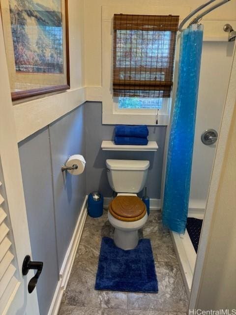 bathroom with toilet and a stall shower