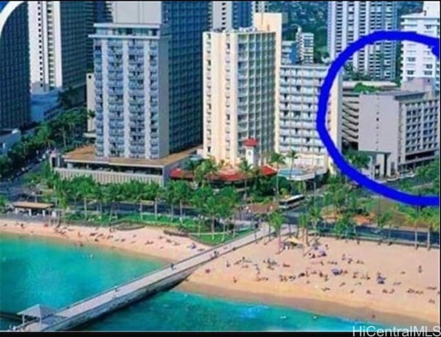 bird's eye view featuring a water view and a beach view