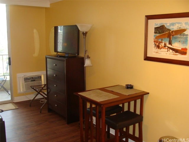 dining room with a wall unit AC and dark hardwood / wood-style flooring