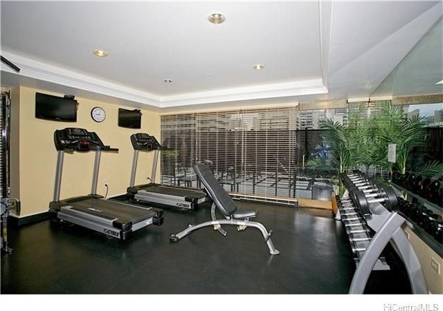 workout area featuring a tray ceiling