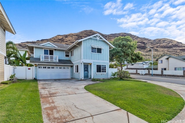 view of front of house featuring a mountain view, a front lawn, and a garage