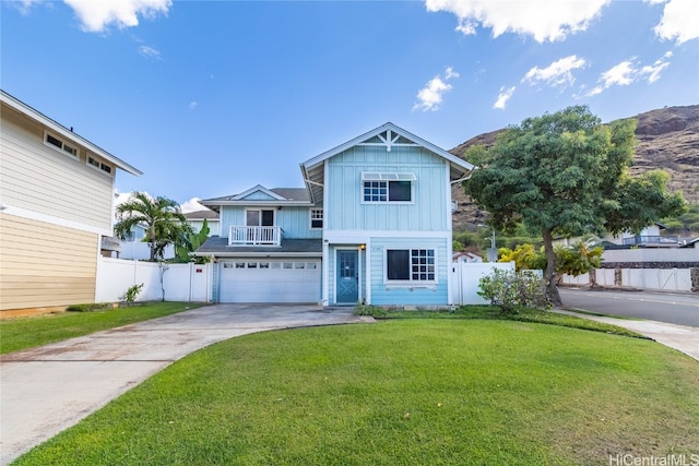 view of front of property with a mountain view, a front lawn, and a garage