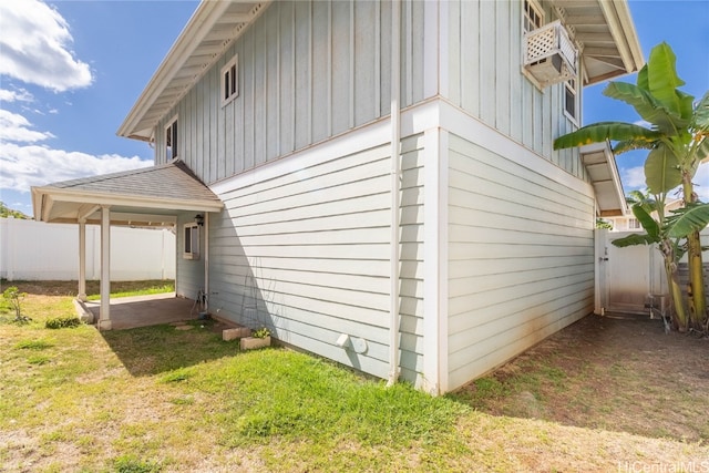 view of side of property with a patio area and a lawn