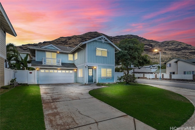 view of front of house with a yard, a mountain view, and a garage