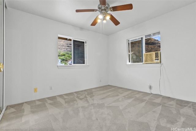 spare room with ceiling fan, cooling unit, plenty of natural light, and light colored carpet