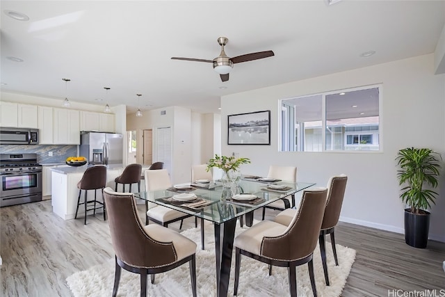 dining area with light hardwood / wood-style floors and ceiling fan