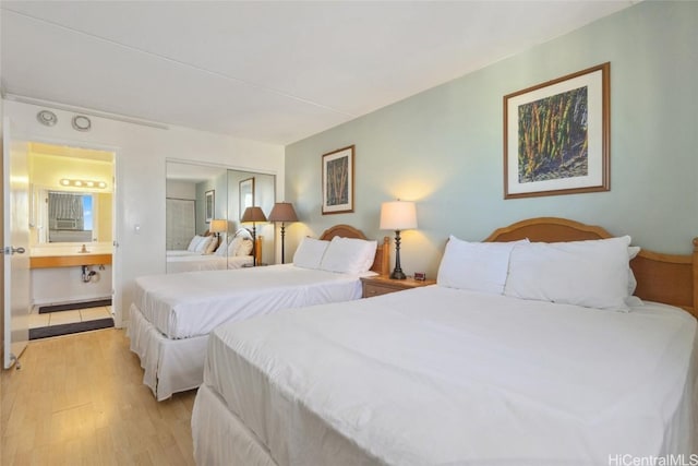 bedroom featuring sink and light hardwood / wood-style flooring