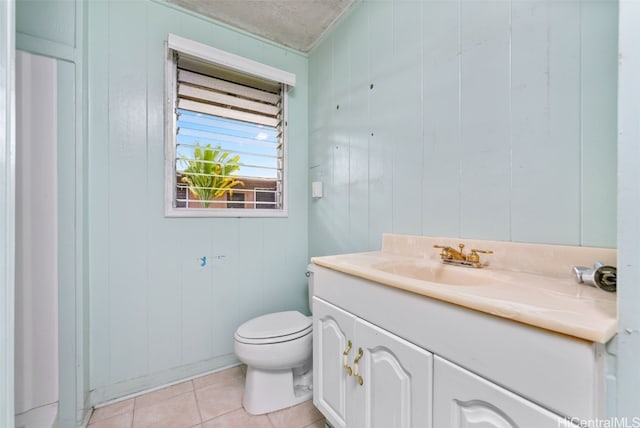 bathroom with vanity, wood walls, and toilet