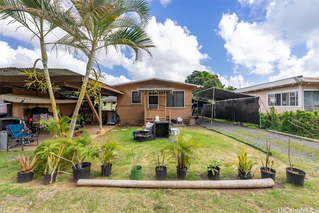 back of house with a patio and a lawn