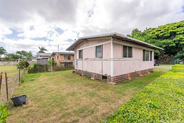 view of side of home with a yard