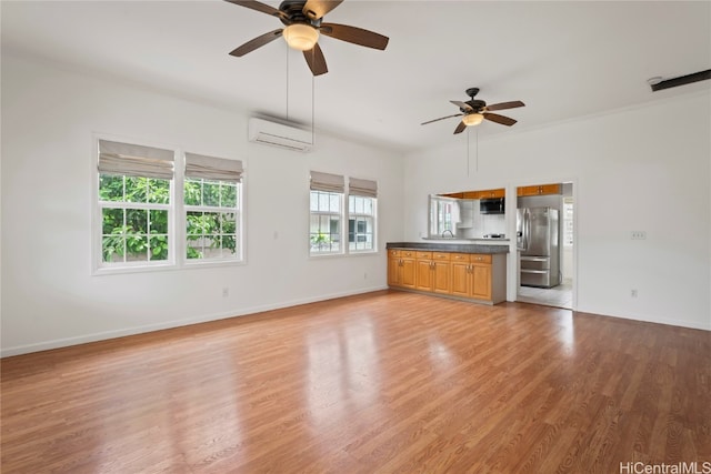 unfurnished living room featuring ceiling fan, an AC wall unit, wood-type flooring, and sink