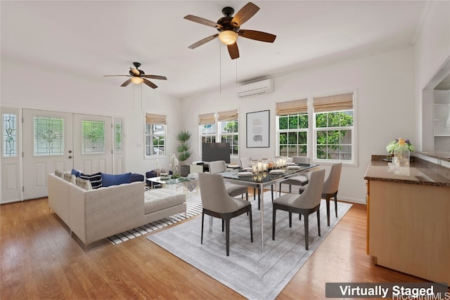 dining area featuring an AC wall unit, light wood-type flooring, and ceiling fan