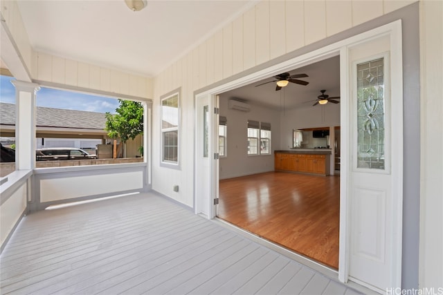 unfurnished sunroom with ornate columns, plenty of natural light, and a wall unit AC