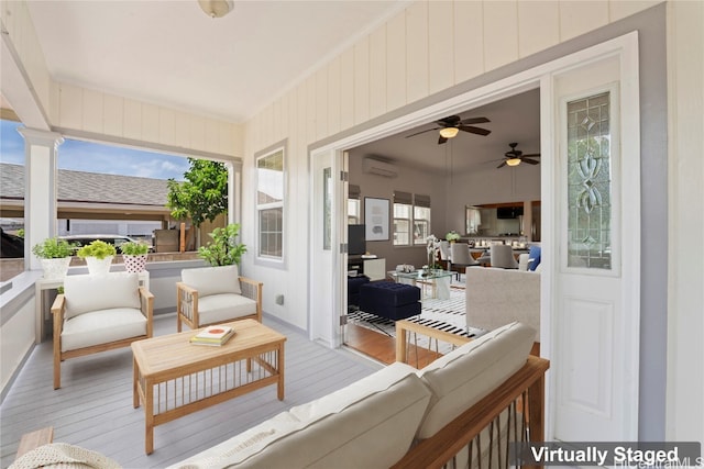 sunroom featuring a wealth of natural light, a wall mounted AC, and ceiling fan